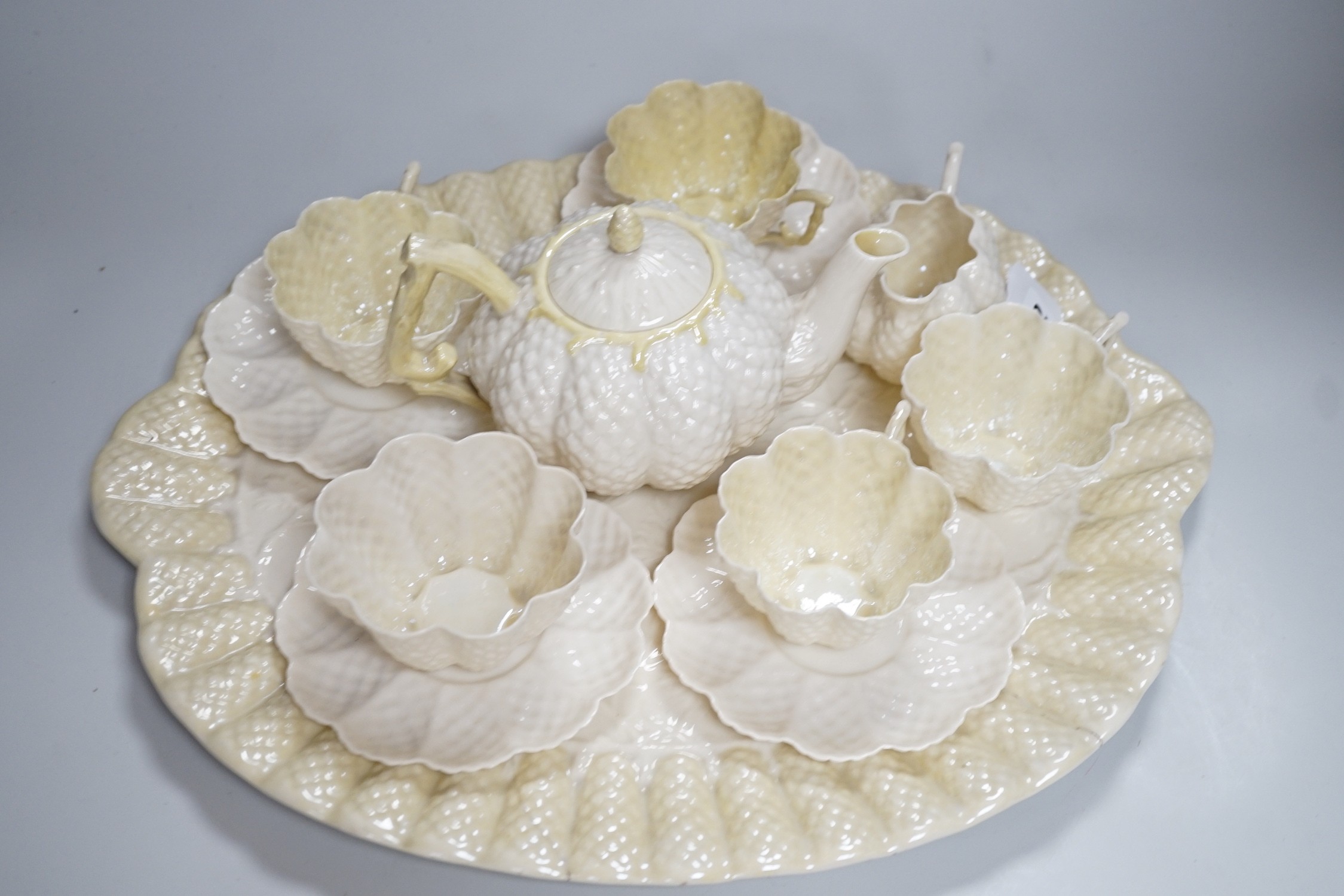 A Belleek porcelain teaset comprising tray, teapot, milk jug, sugar bowl, four cups and four saucers